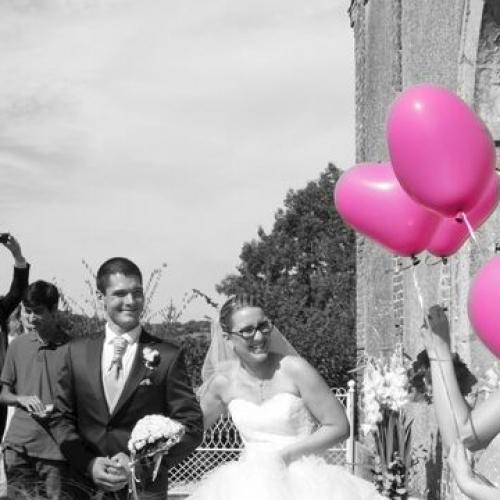 Photo noir et blanc des mariés et ballons roses