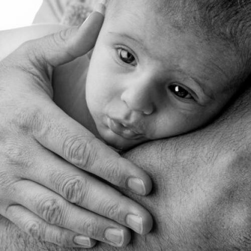 Photo portrait de bébé en noir et blanc dans les bras de son père